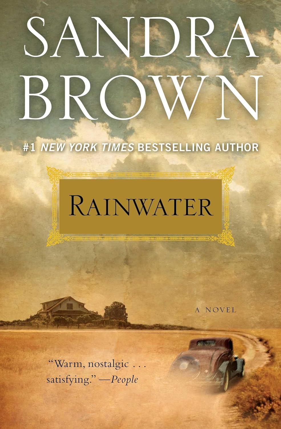 Cover of "Rainwater" by Sandra Brown. A vintage car drives on a dusty road toward a farmhouse under a cloudy sky, evoking nostalgia and warmth.