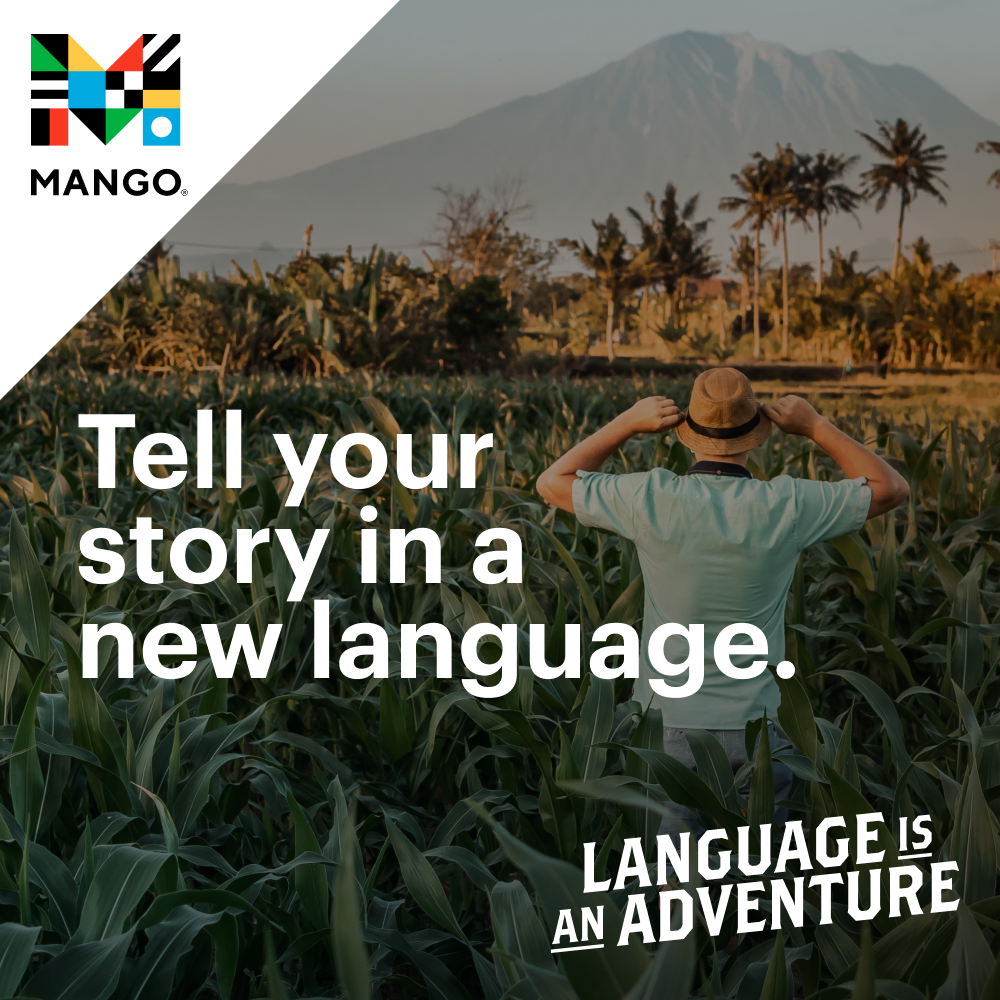 A person in a field of corn faces a distant mountain and palm trees, wearing a hat. Text reads, "Tell your story in a new language. Language is an adventure." Mango logo